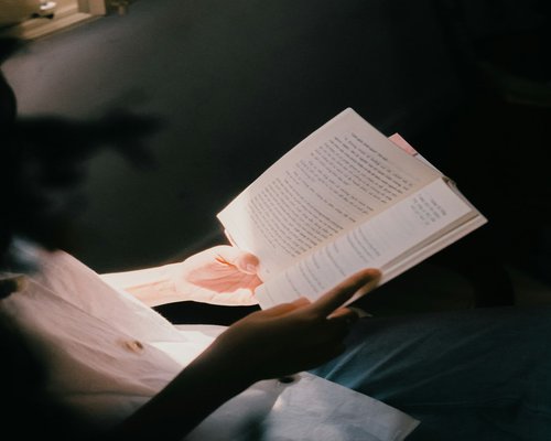 Person reading a book peacefully in the evening